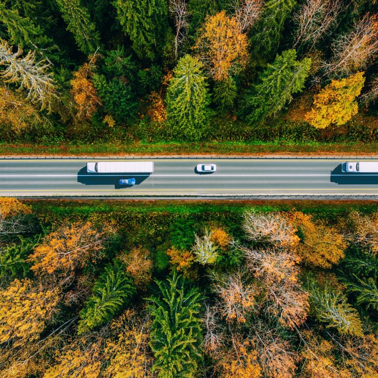 Aerial,View,Of,White,Trucks,And,Cars,Driving,On,Asphalt